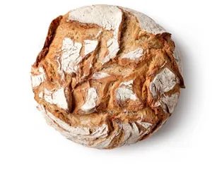 Een rond, bebloemd landbrood met krokante korst